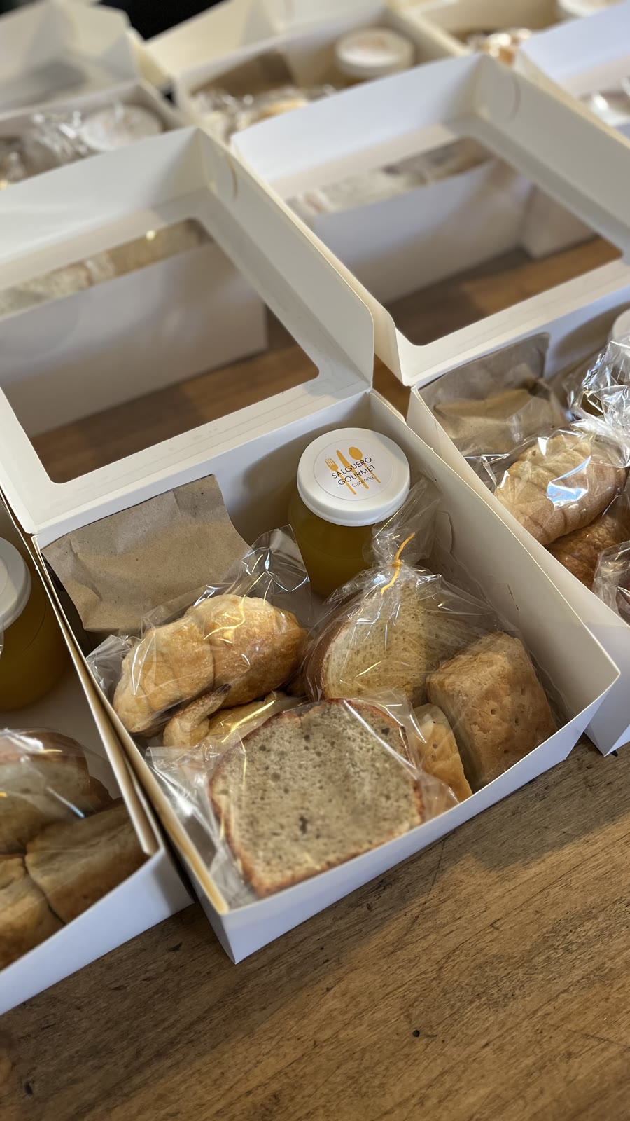 Boxes de desayuno abiertos con budín, pan y limonada